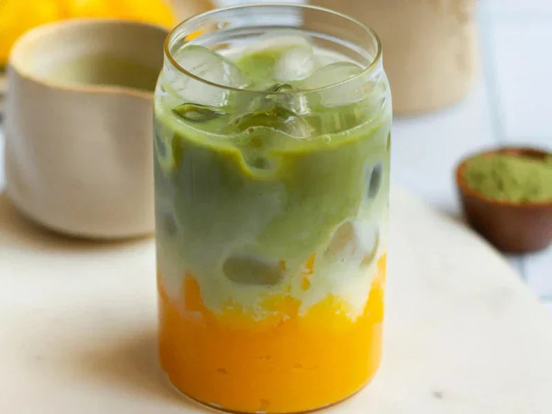 Mango coconut matcha latte layered iced drink with coconut foam in a glass Dubai style
